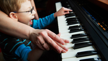 lapsi painelee pianon näppäimiä