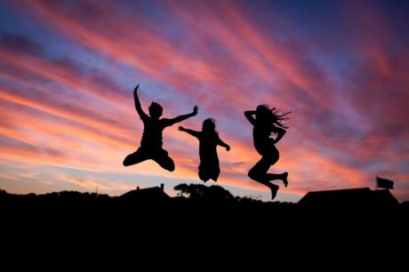 Valokuvassa on kolme nuorta, jotka hyppäävät yhdessä ilmaan.