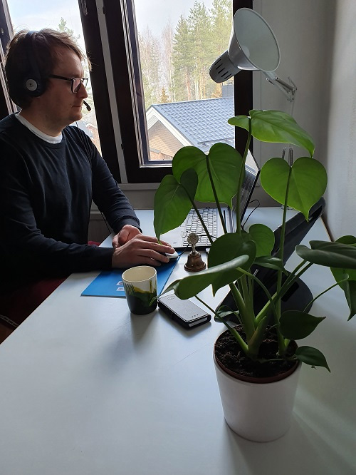Lauri Räty istuu tietokoneella kuulokkeet päässä ja mikrofoni edessä.